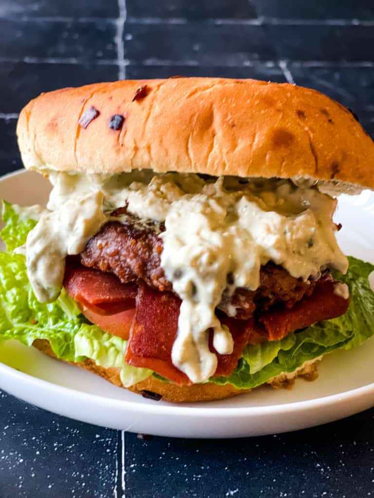 impossible burger with bacon, tomato, lettuce, and vegan blue cheese dressing