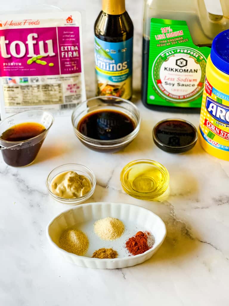 ingredients needed for baked tofu including tofu aminos, soy sauce, cornstarch, seasonings, and oil