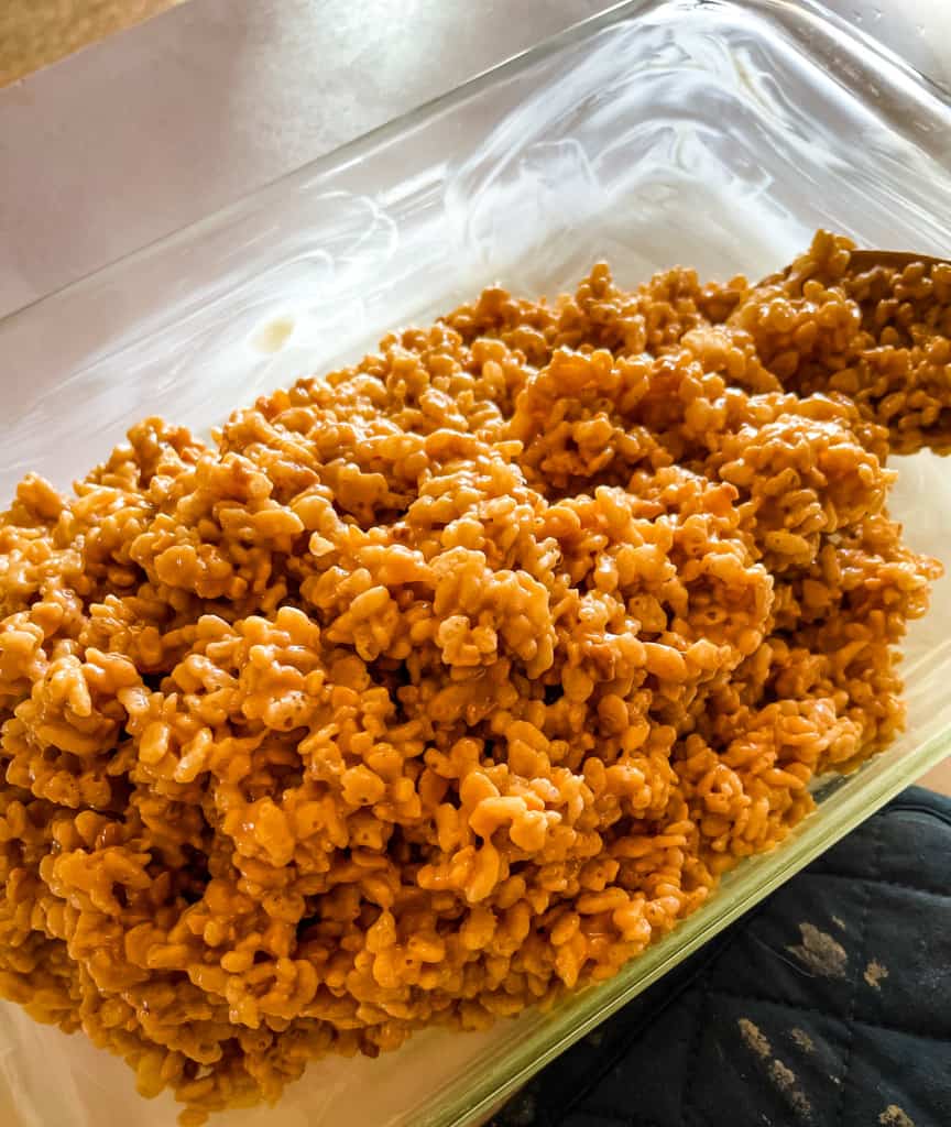 turning the hot cooked rice krispy treat mixture into the pan
