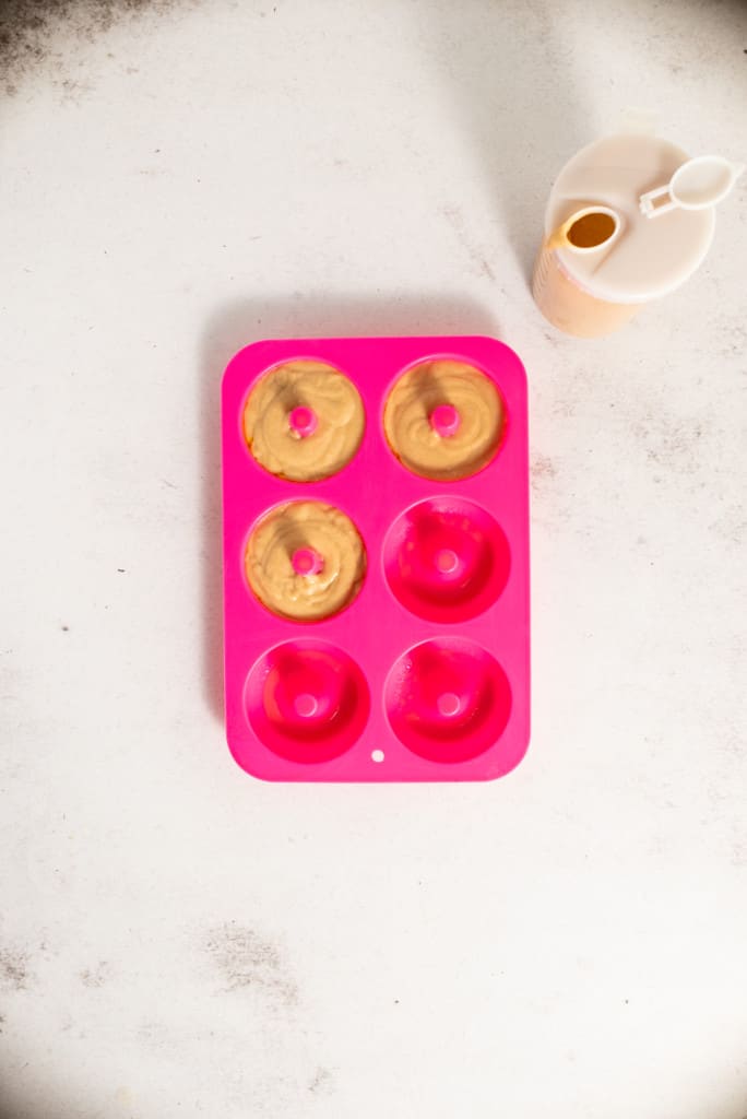 pouring batter into donut moulds