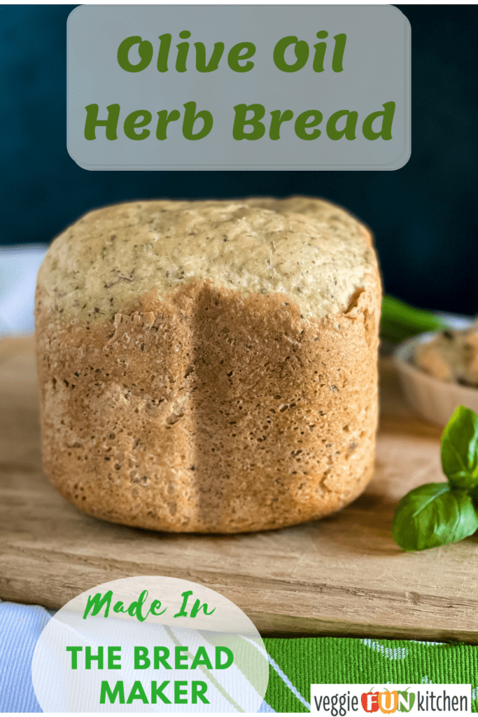 baked loaf of olive oil herb bread on a cutting board with pinterest text overlay