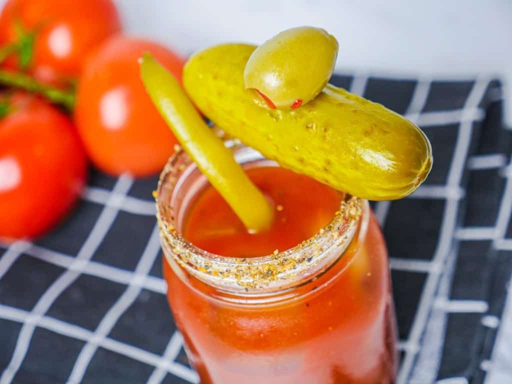 bloody mary in jar with pickle olive and bean on top