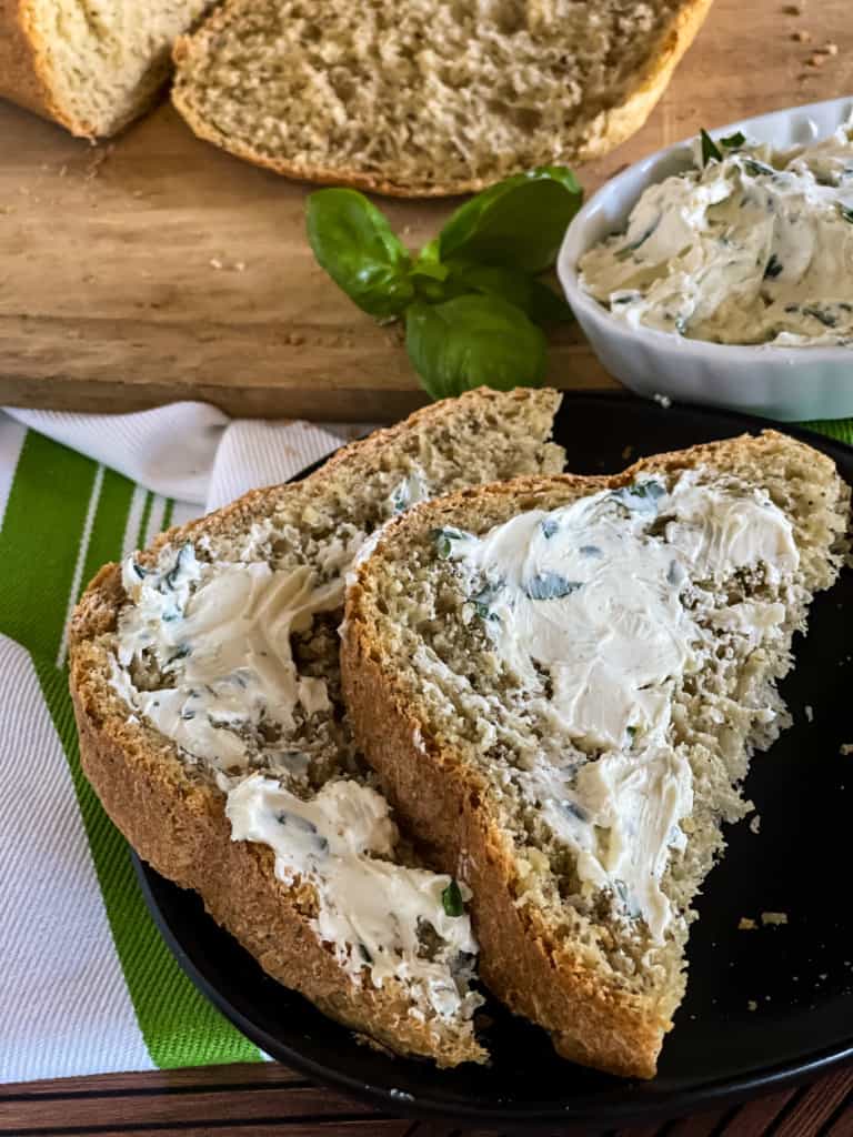 two slices of olive oil herb bread spread with basil garlic butter