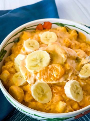 scooping out a large spoonful of orange fluff salad