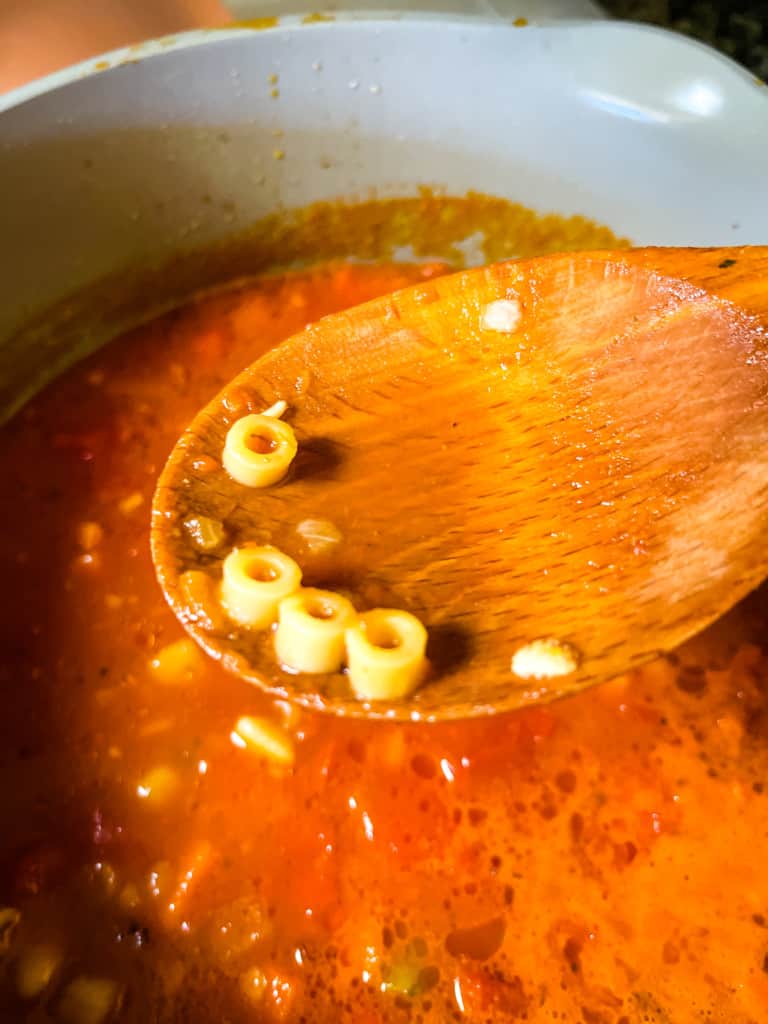 cooked pasta on a wooden spoon