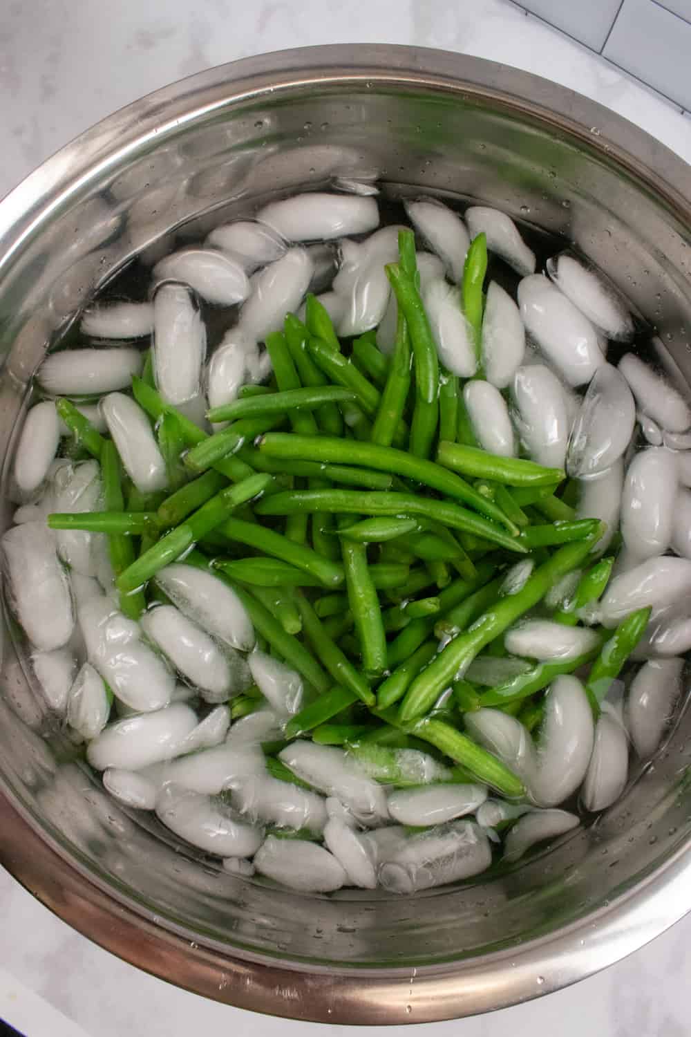 cooling the blanched green beans in ice water