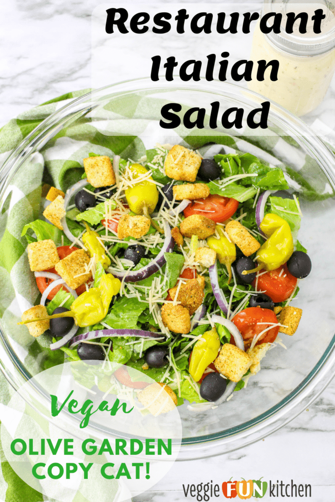 glass bowl with Italian salad tossed with dressing with pinterest text overlay