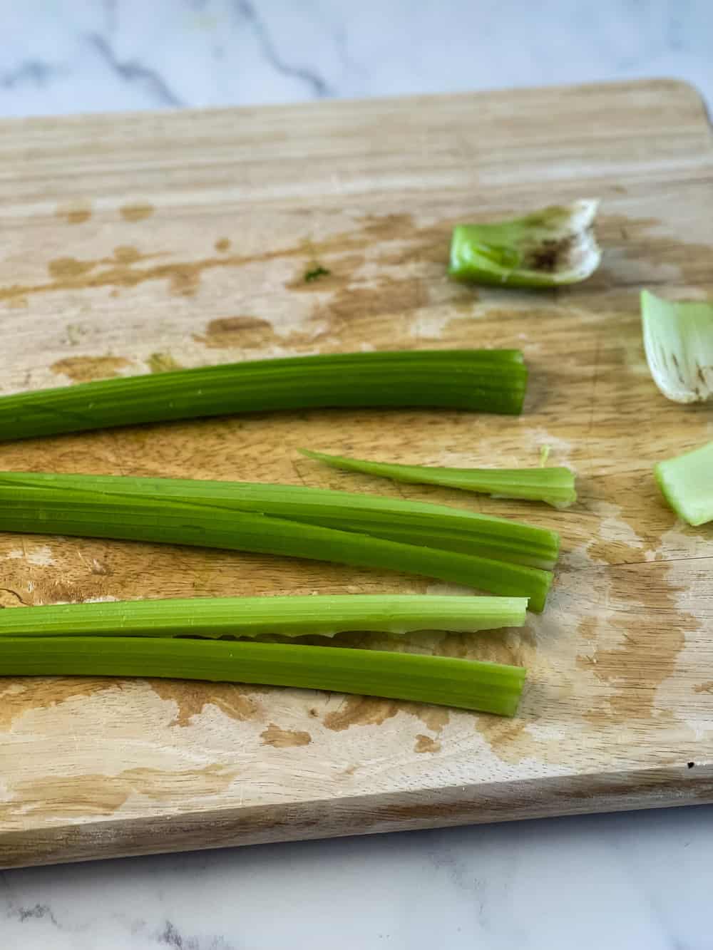 cutting the celery sticks and showing how to slice long ways into each stalk before cutting