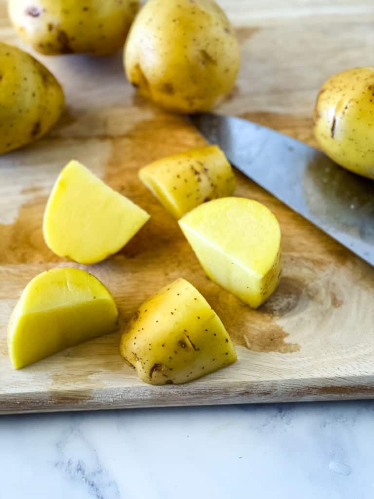 cutting the washed potatoes into fourths