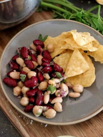 vegan bean salad on plate with chips