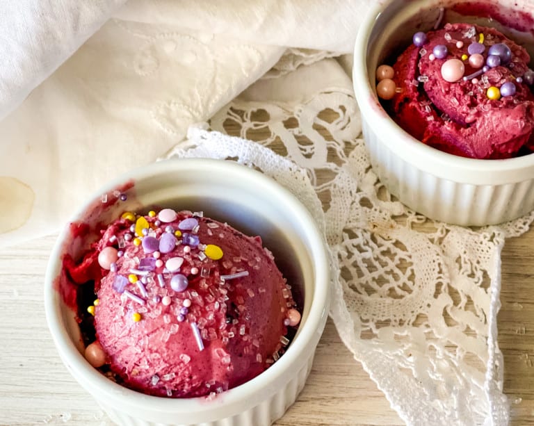 two containers with blueberry cheesecake ice cream with sprinkles on top