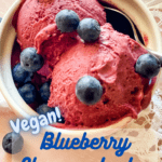bowl of blueberry cheesecake ice cream with fresh blueberries on top with pinterest text overlay