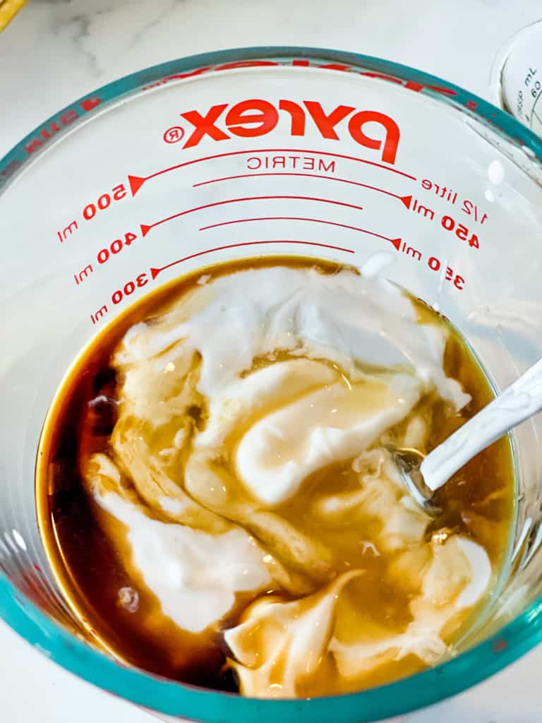 mixing together ingredients for coffee ice cream in glass measuring cup