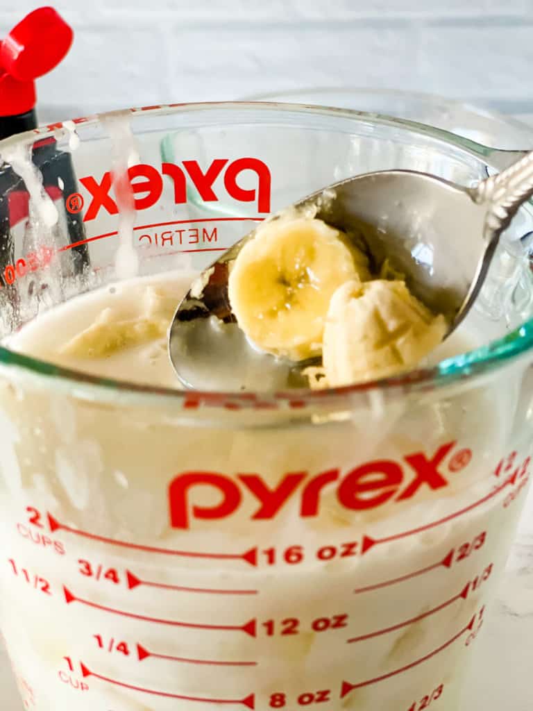 placing banana slices in pyrex measuring cup