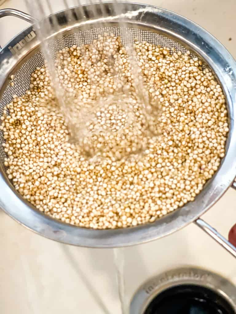 rinsing quinoa in a mesh strainer