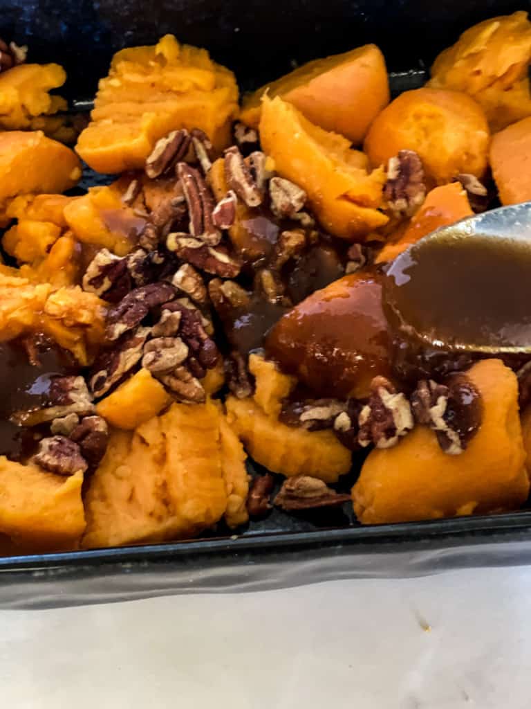 spooning the melted butter brown sugar mixture onto the canned yams and pecans