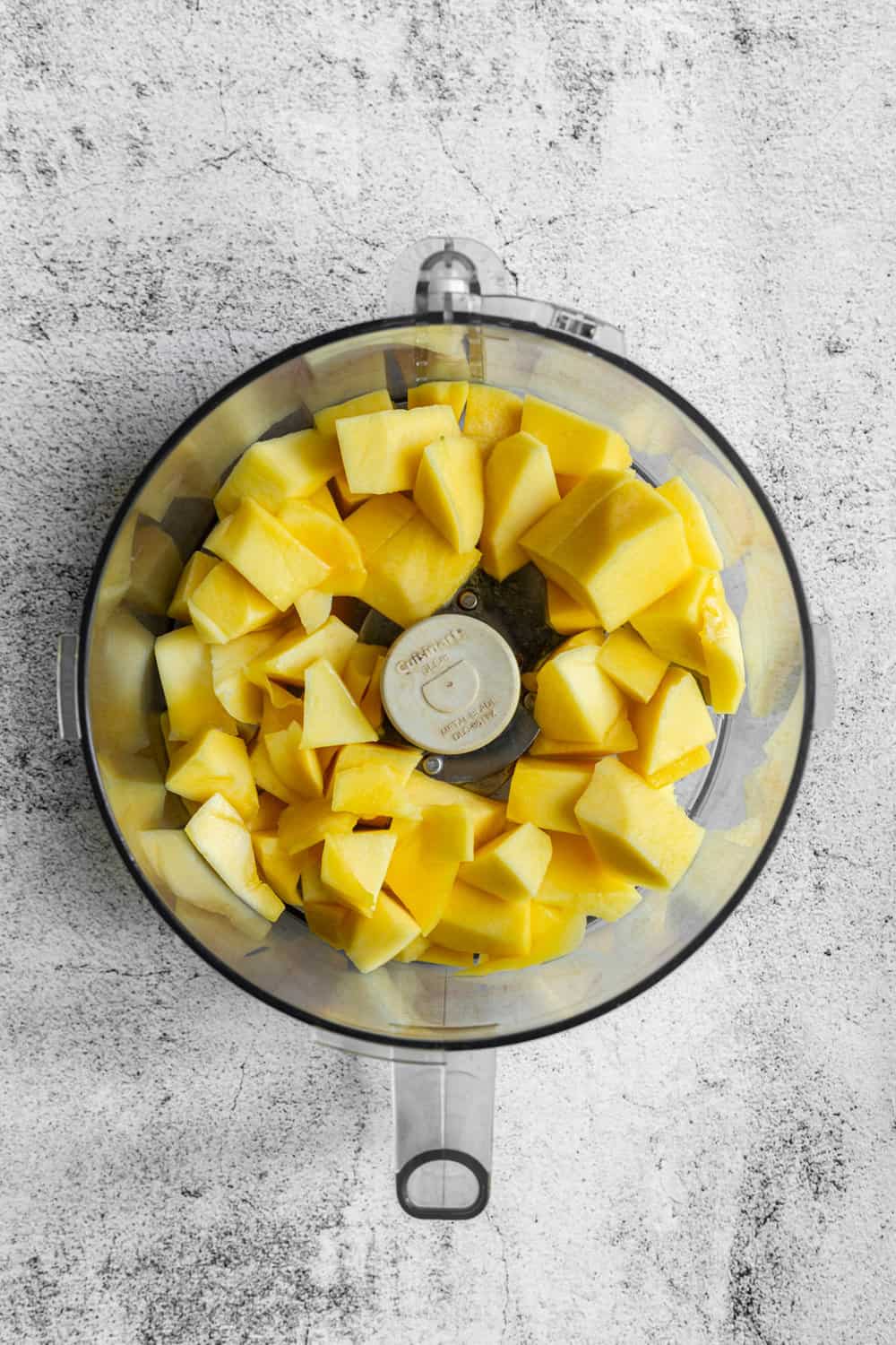 chunks of fresh mango in the food processor bowl