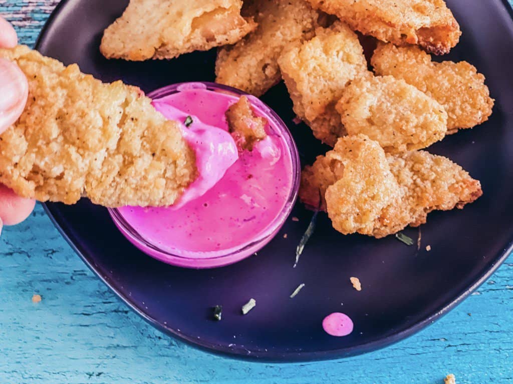 pink sauce with vegan chick nuggets with one dipping in the sauce