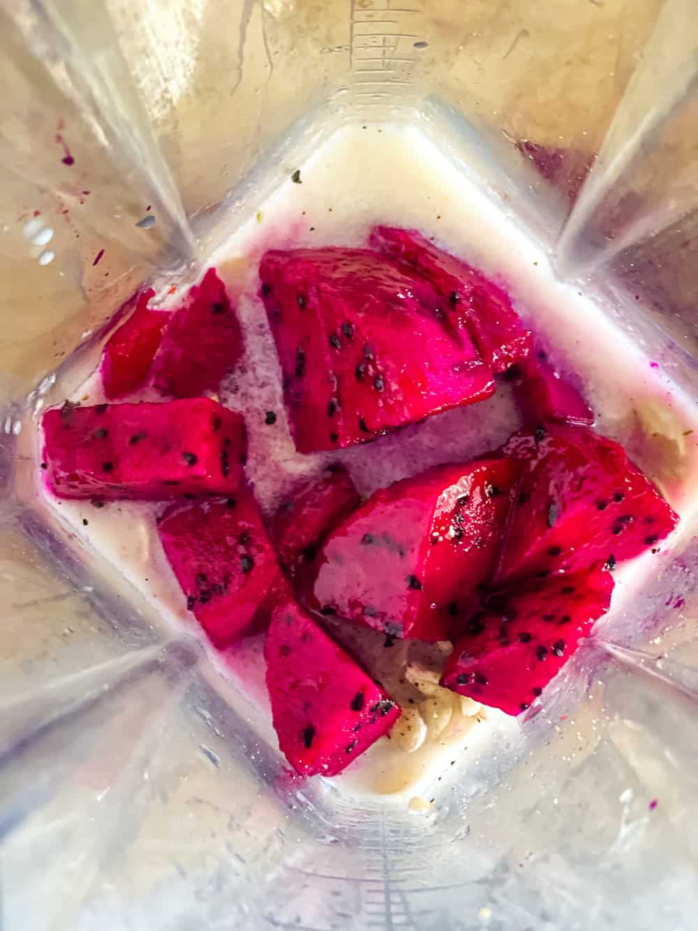 ingredients in the blender for pink sauce with dragon fruit on top
