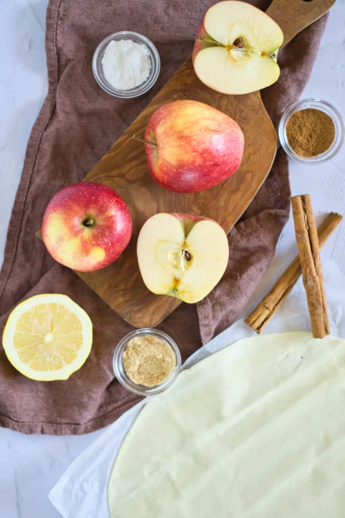 apples, lemon and cinnamon on a cutting board