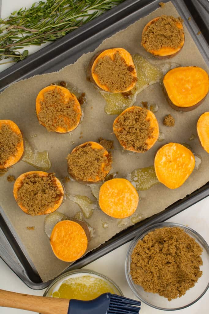 adding the brown sugar to sweet potato rounds