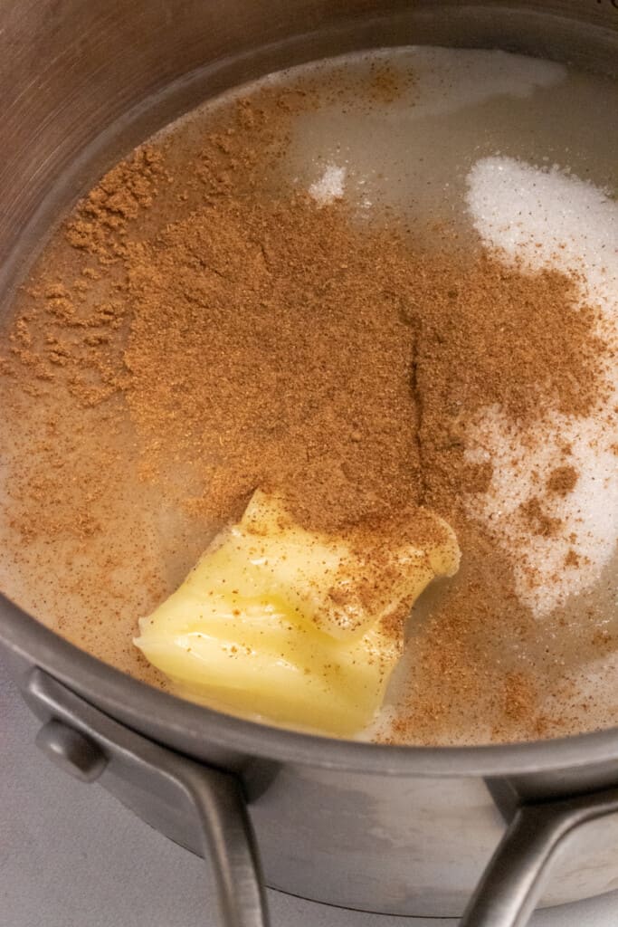 vegan butter, oat milk, cinnamon and sugar in a pan ready to boil