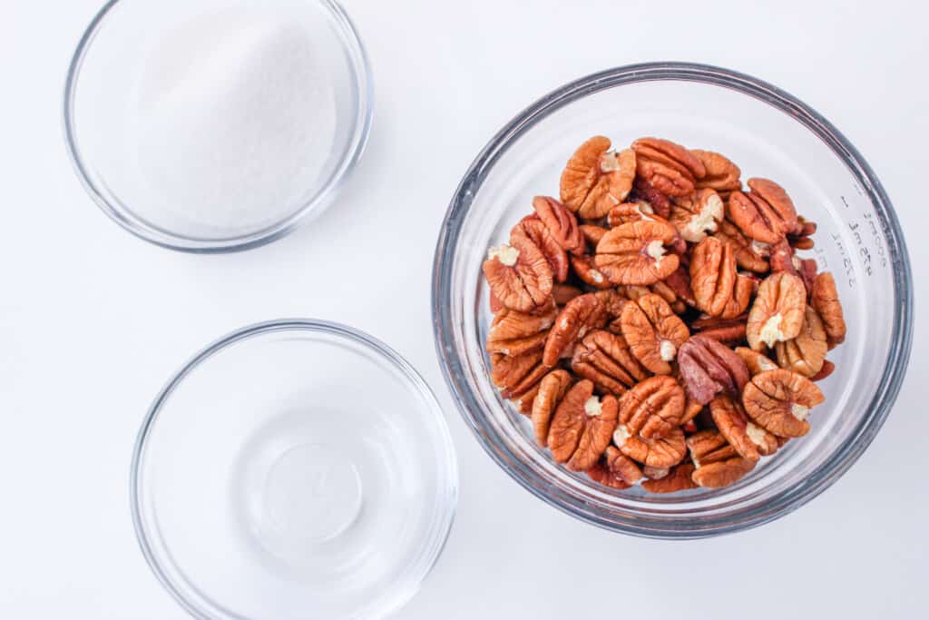 ingredients needed for candied pecans including pecan halves sugar and water