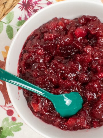 bowl of cranberry apple sauce with green spoon