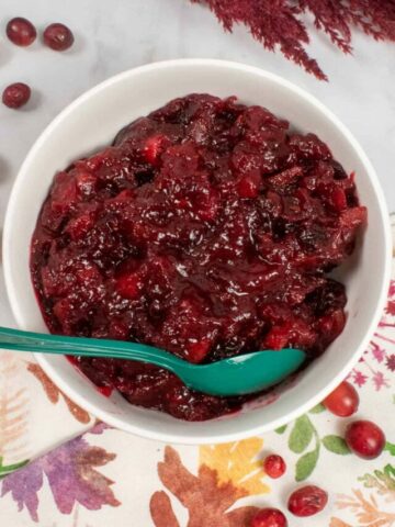 bowl of apple cranberry sauce with green spoon