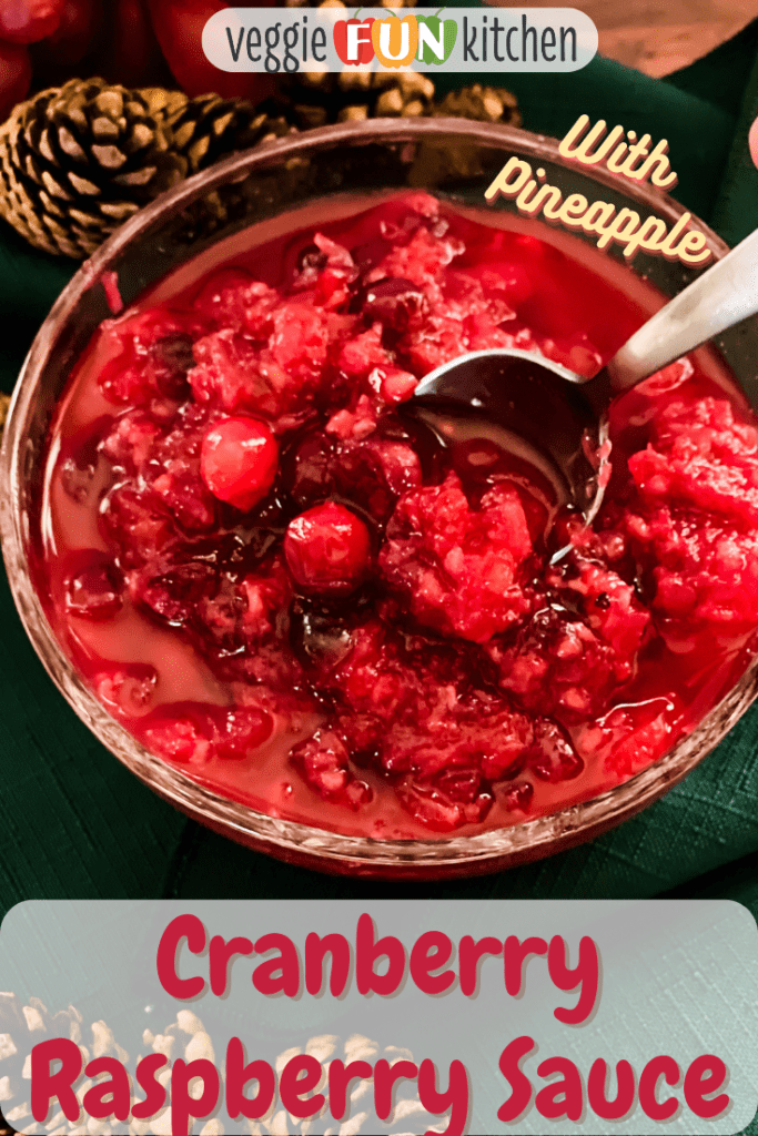 Bowl of raspberry Cranberry sauce with spoon in bowl and pinecones in background with pinterest text overlay