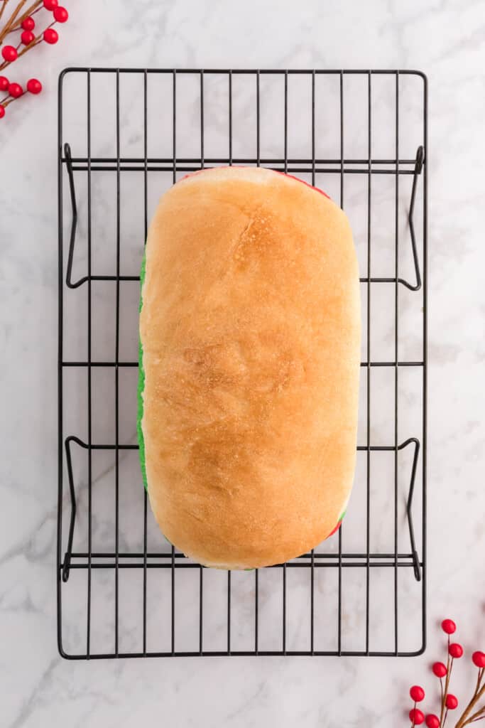the baked loaf of bread cooling on a wire rack