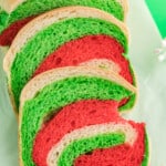 top front view of baked christmas loaf with three slices cut from loaf with a bite taken from one of the slices