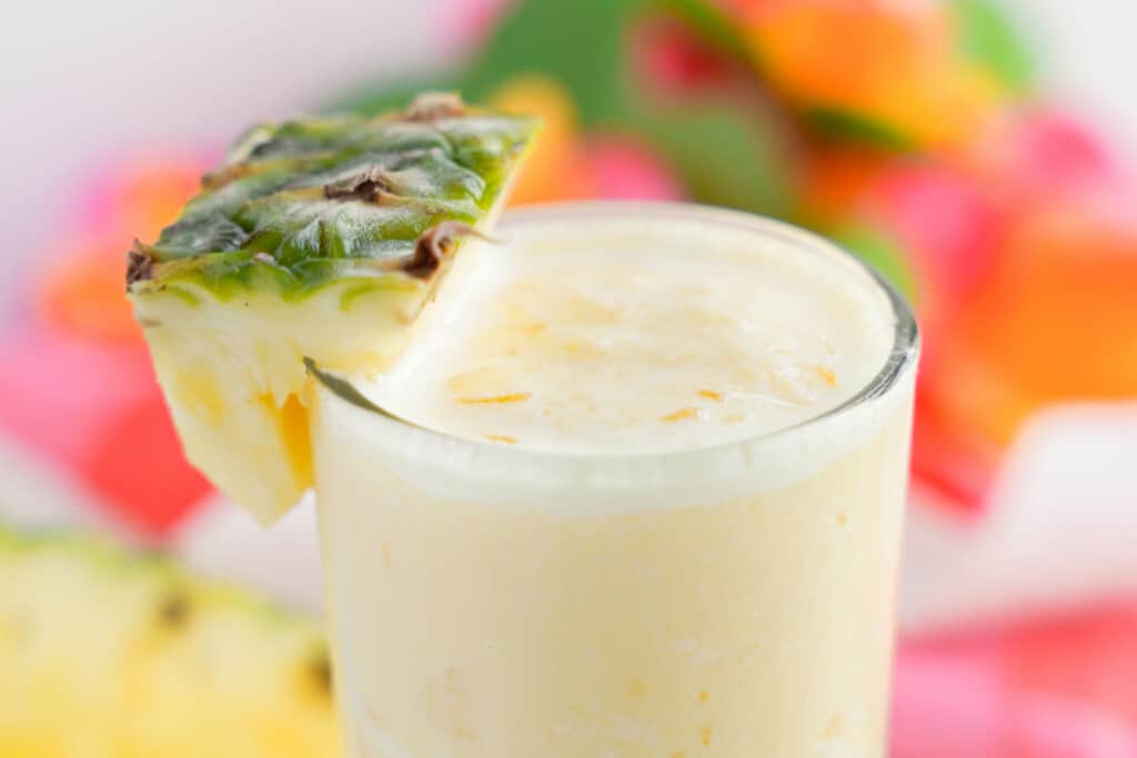 orange pineapple smoothie with pineapple chunk for garnish