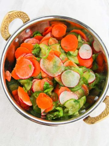 cucumber carrot salad in a brass bowl