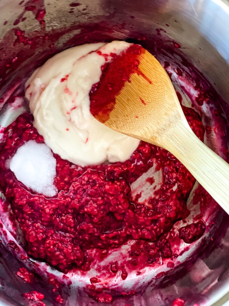 mixing the coconut butter and coconut oil into the warm raspberries