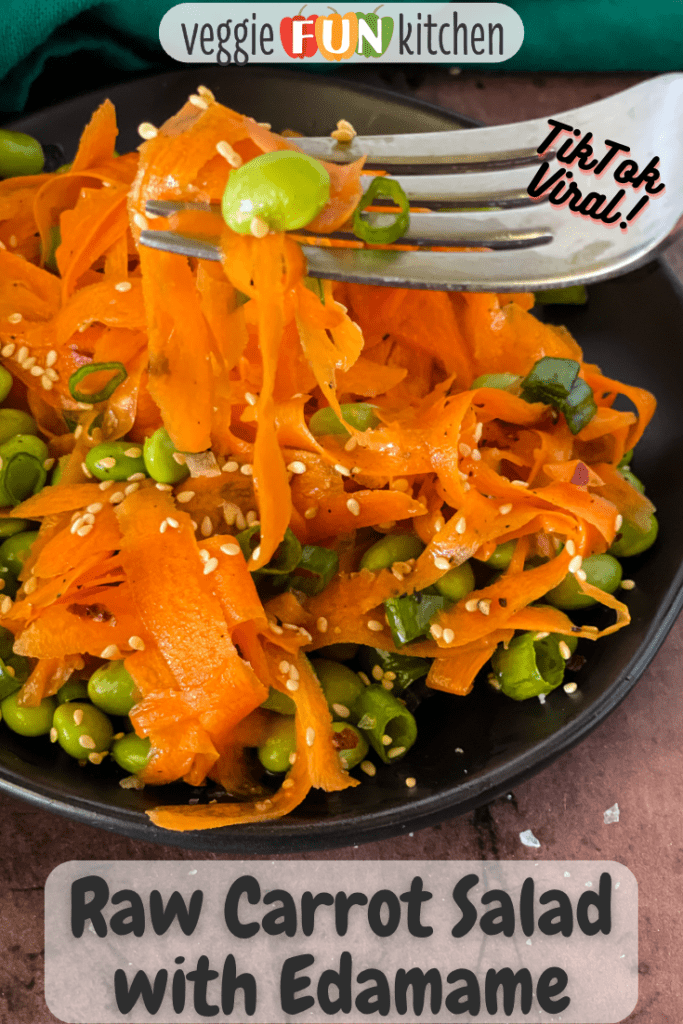 plated raw carrot salad with edamame with some on fork with pinterest text overlay