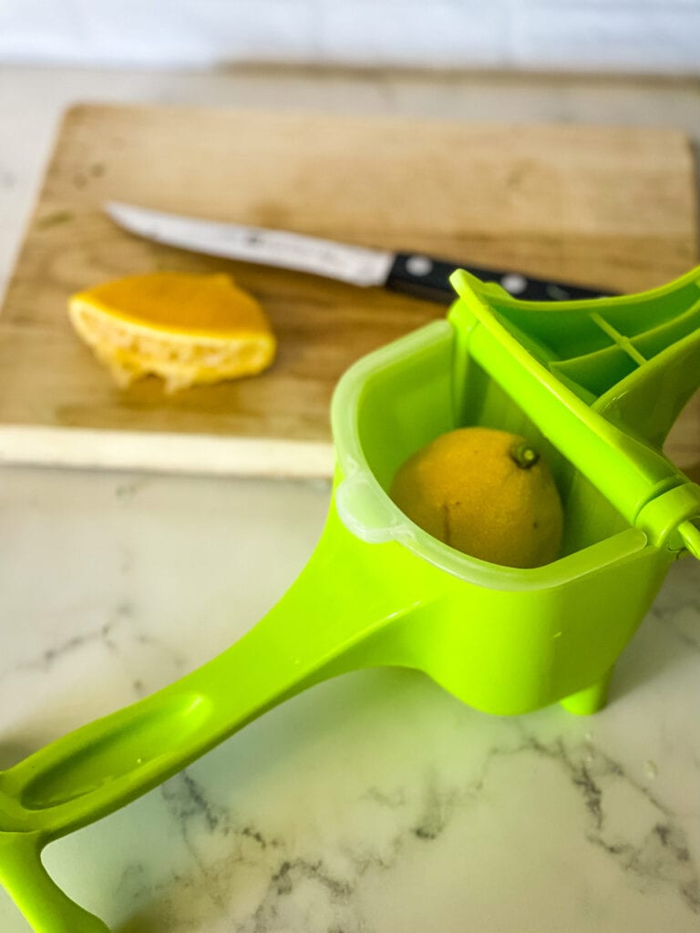 squeezing the lemon with a hand squeezing device
