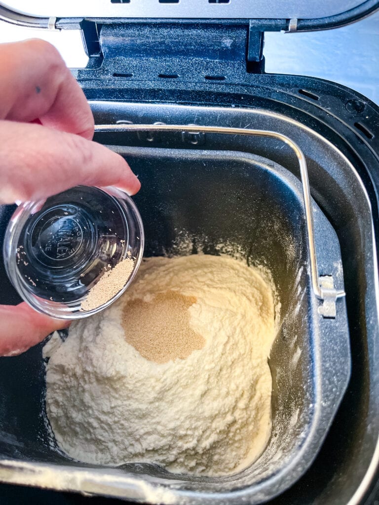 pouring the yeast on top of the flour