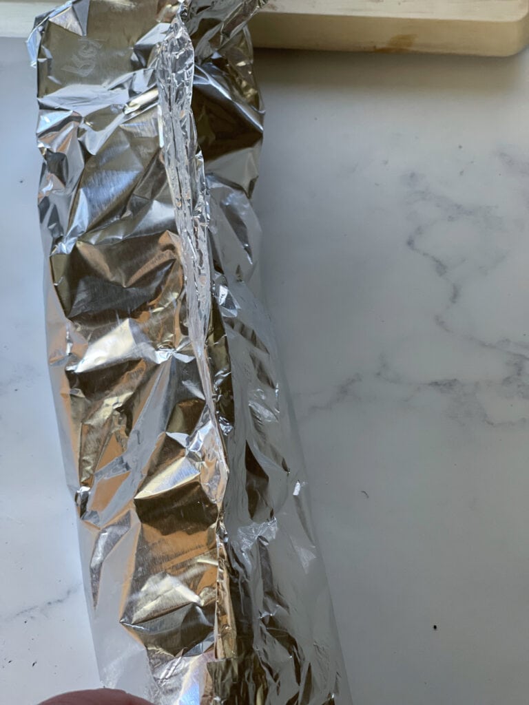 rolling up the foil containing onions and garlic