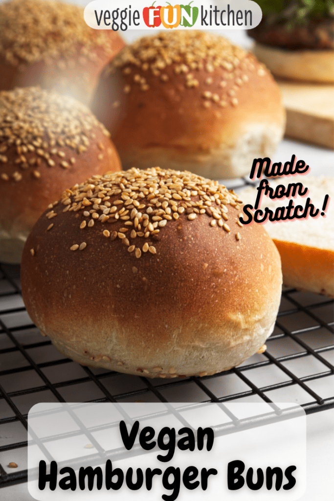 vegan burger buns with sesame seeds on a wire rack with Pinterest text overlay.