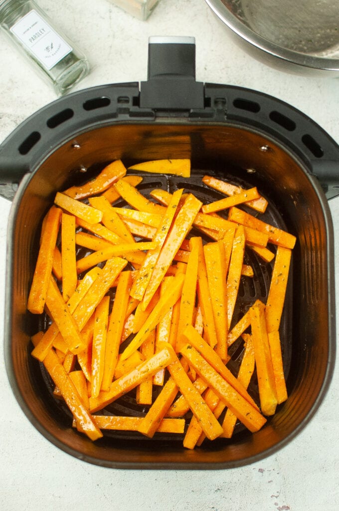 uncooked butternut squash fries in the air fryer.