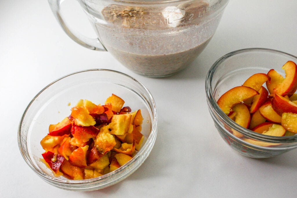 Showing the oatmeal mixture in the middle with a bowl of chopped peaches on the left and sliced peaches on the right.