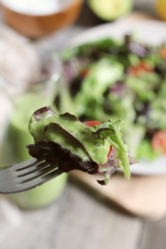 a forkful of salad with green goddess dressing on it.