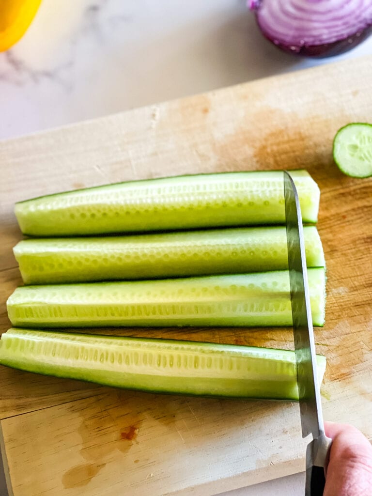 Showing how I cut cucumber by making four lengthwise pieces and slicing down the pieces.