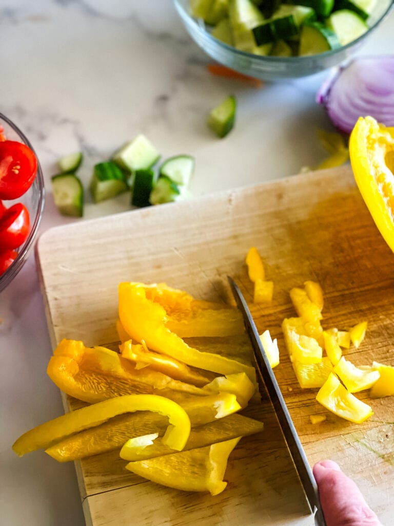 Showing how I dice yellow peppers by making slices first then cutting down the length of the slices.