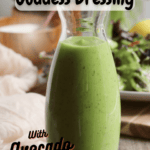 Jar of green goddess dressing in the front with a salad in the background. With pinterest text overlay.