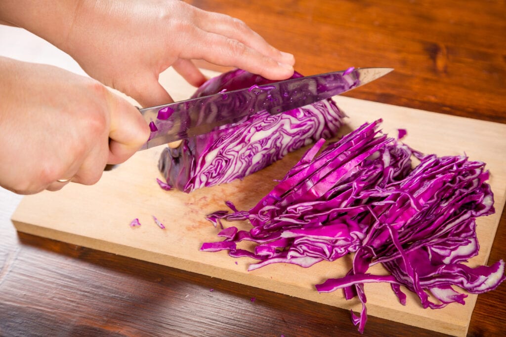 Slicing the red cabbage very thinly.