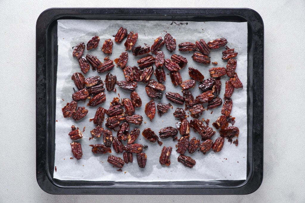 Roasted candied pecans on prepare baking sheet.