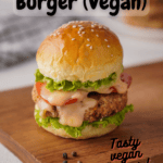 White bean burger on a bun with lettuce, tomato and vegan burger sauce. Sitting on a wooden cutting board with pinterest text overlay.