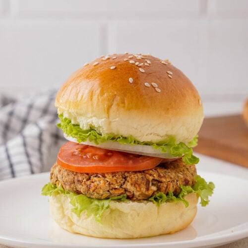 White bean patty on a bun with lettuce, tomato and onion.